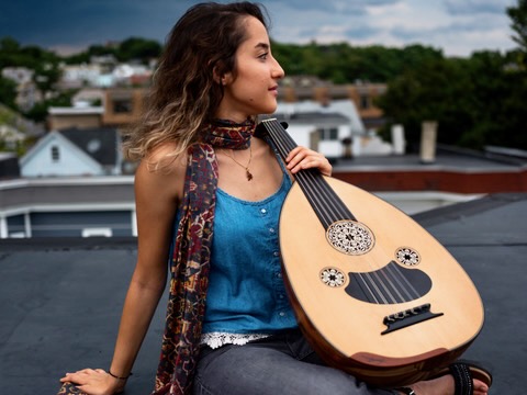 Bahar Badieitabar sitting on rooftop with her oud 